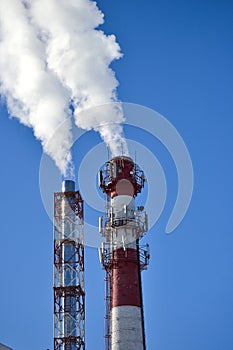 Two pipes. Industrial smoke from a chimney against the sky