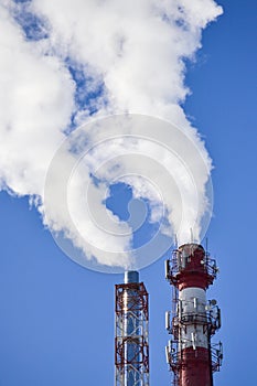 Two pipes. Industrial smoke from a chimney against the sky