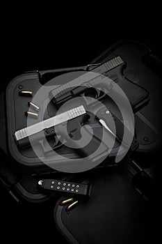 Two pistols, 9mm cartridges and a penknife lie on a plastic gun case. Self-defense and survival kit. Compact edged weapons and