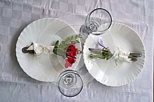 Two place settings on table decorated with flower