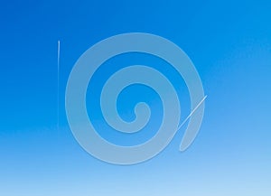 Two planes fly high in the blue sky