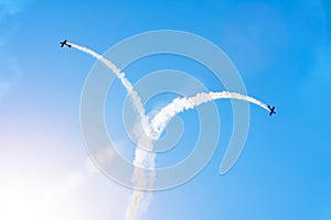 Two planes scatter in the sky leaving a smoky trail, in the form of a fountain figure