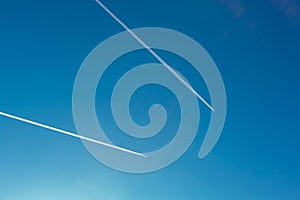 Two planes with traces on a blue sky background.