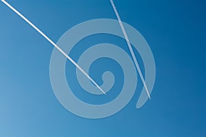 Two planes with traces on a blue sky background.