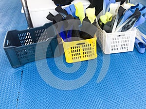 Two plastic boxes, baskets with multi-colored rubber diving flippers for swimming, diving equipment onboard the box, boat, cruise