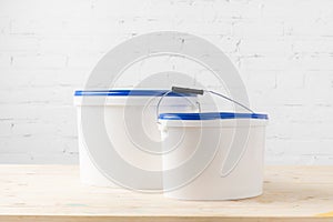 Two plastic buckets with paints