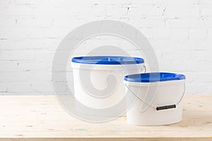 Two plastic buckets with paints