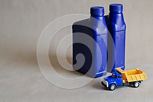 Two plastic canisters with car oils and a toy dump truck