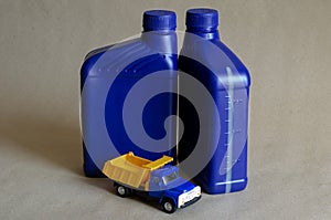 Two plastic canisters with car oils and a toy dump truck