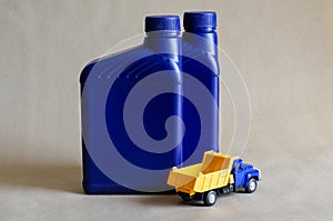 Two plastic canisters with car oils and a toy dump truck