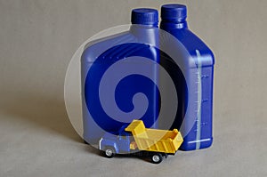 Two plastic canisters with car oils and a toy dump truck