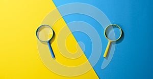 Two plastic magnifiers on a yellow-blue background