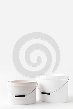 Two plastic white buckets with paints