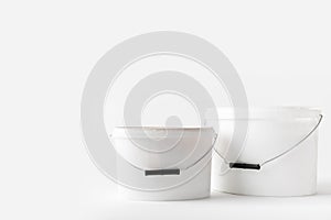 Two plastic white buckets with paints