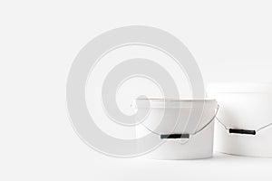 Two plastic white buckets with paints