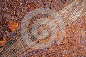 Two plate of old rotten rusted metal lying on a wooden board. Iron rust and aged wood texture background. Macro shot of