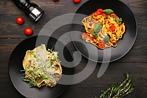 Two plate with pasta top view. alfredo pasta with beef and marinara pasta on wooden table with ingredients, pepper and cheese