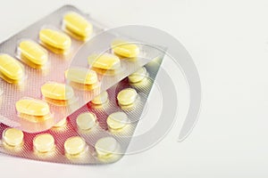 Two plates with different tablets of yellow color on a white background