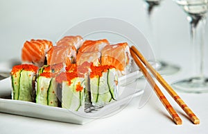 Two plates of salmon and cucumber sushi rolls