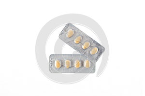 Two plates of yellow tablets on white isolated background