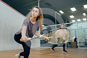 Two players with squash racket playing on court