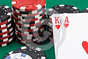 Two playing cards close-up on the background of poker chips on a green table