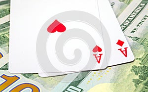 Two playing cards on money background. Winning poker hand. Hearts and diamonds ace on table.