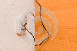 Two plugs in the socket in a modern interior. Safe connection of electrical appliances concept