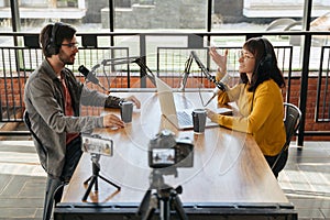 Two podcasters recording video podcast together in studio