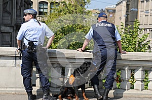Two police men with a police dog obeying the demonstration at Urania in ZÃÂ¼rich city