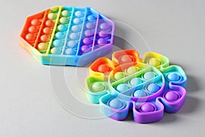 Two popular silicone colorful antistress pop it toys for child on light background. Simple dimple. Close-up