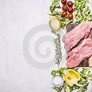 Two pork steak with vegetables on a cutting board spices herbs border , place text wooden rustic background top vi