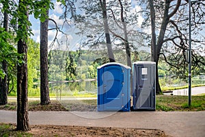 Two portable toilets in a park