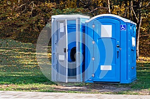 Two portable toilets in a park photo
