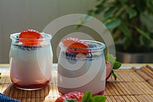 Two portions of homemade berries yogurt in fresh environment. Healthy diet concept