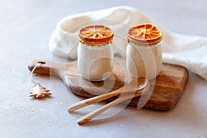 Two portions of joghurt decorated with dry orange slices, winter breakfast