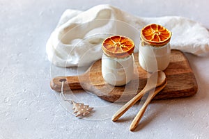 Two portions of joghurt decorated with dry orange slices, winter breakfast