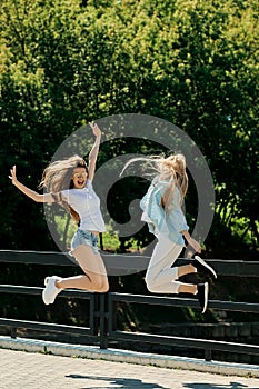 Two positife girls jumping together
