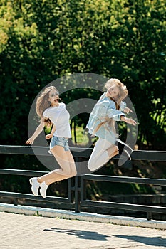 Two positife girls jumping together