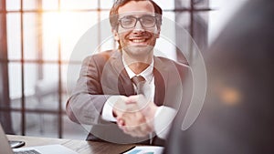 Two positive confident businessmen shaking hands over meeting table after negotiation,