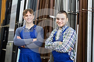 Two positive workers posing in PVC shop