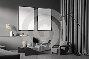 Two posters in the dark grey living room with ledge and armchairs