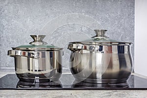Two pots are on an electric or induction hob