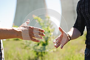 Two power line tower workers with handshaking.