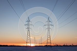 Two Power Transmission Towers Against a Prairie Sunset