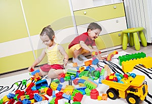Two preschool children build castles with plastic cubes