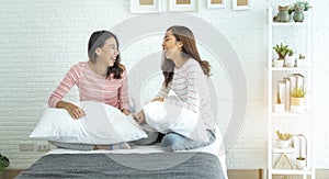 Two pretty best friends forever girlfriend talk, hug and laugh together on bed at cozy home relation fall in love. Lesbian couple