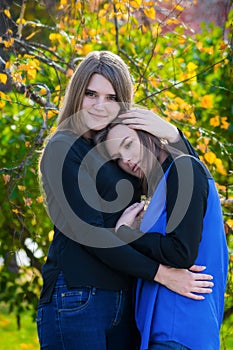 Two pretty girlfriends are hugging
