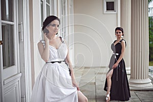 Two pretty girls in black and white long dresses photo