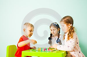 Three kids playing ludo game at home